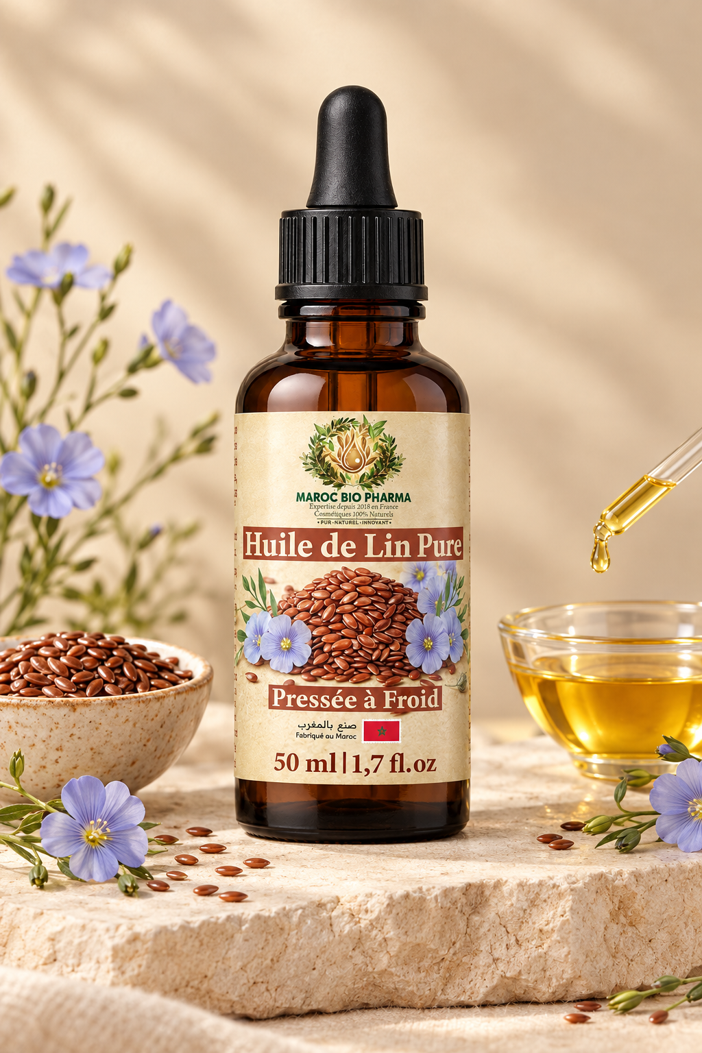 Huile de lin Maroc Bio Pharma dans une mise en scène naturelle avec graines, fleurs de lin et pipette